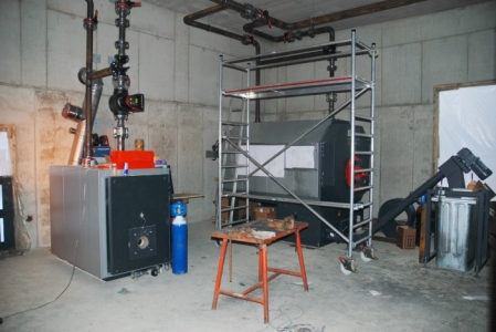 Das Bild zeigt das Innere des Heizwerkes mit dem Gaskessel und Pelletkessel